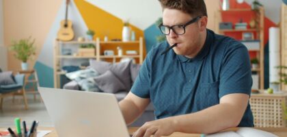 person studying at desk with laptop and notes